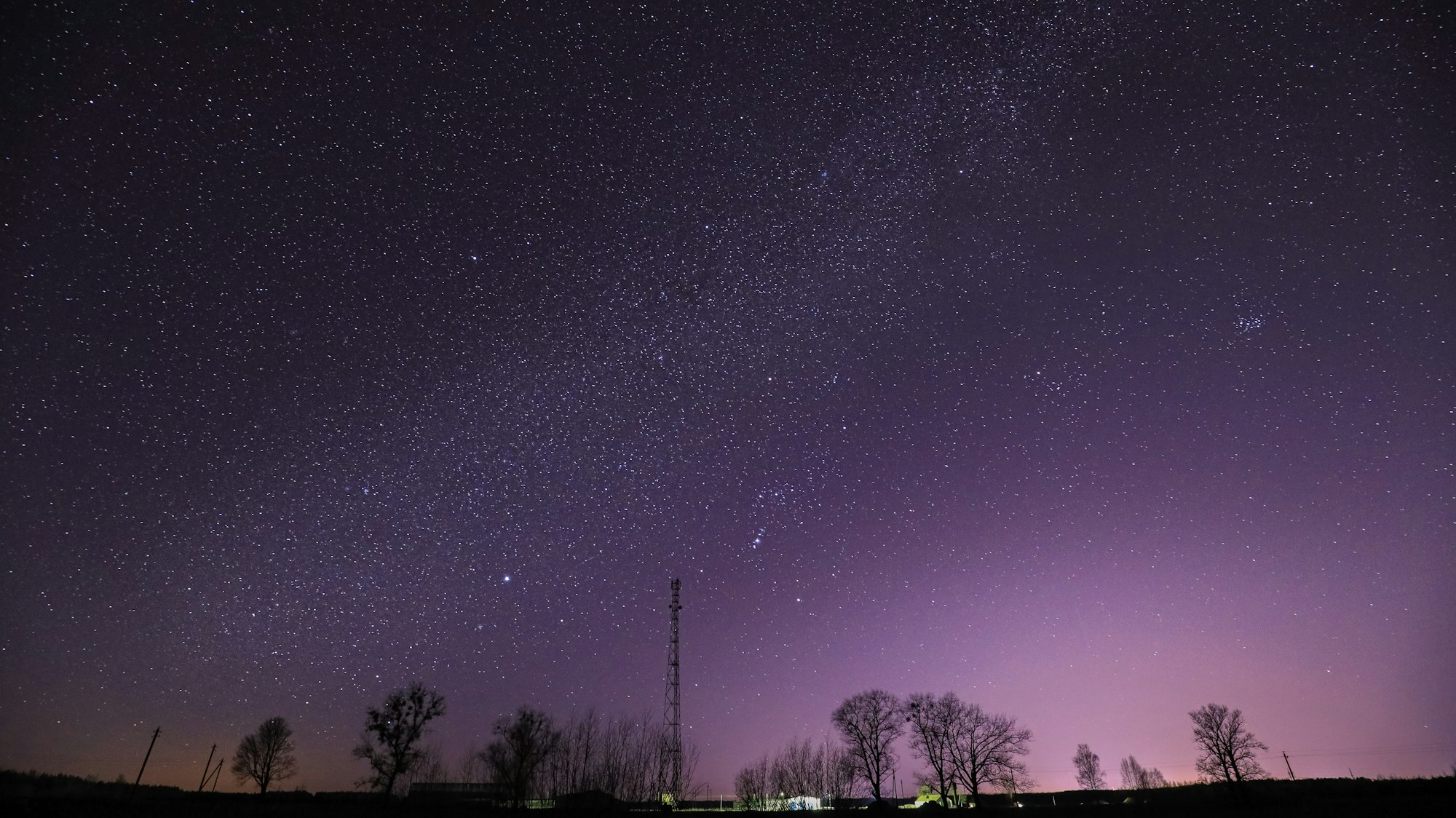 Real Night Sky Stars Above Landscape With Telecommunications Cell Phone Tower Or With Antenna